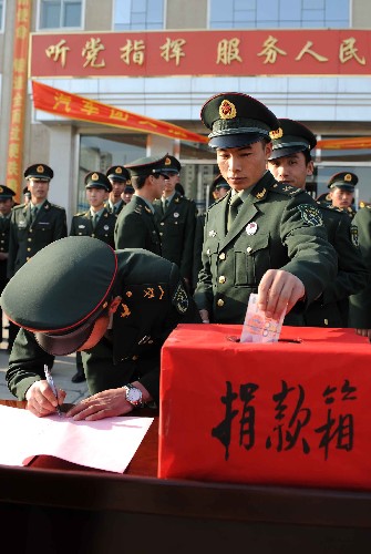 5月13日,中國(guó)人民解放軍內(nèi)蒙古軍區(qū)某汽車(chē)團(tuán)官兵在為四川地震災(zāi)區(qū)捐款。 新華社記者 張領(lǐng) 攝