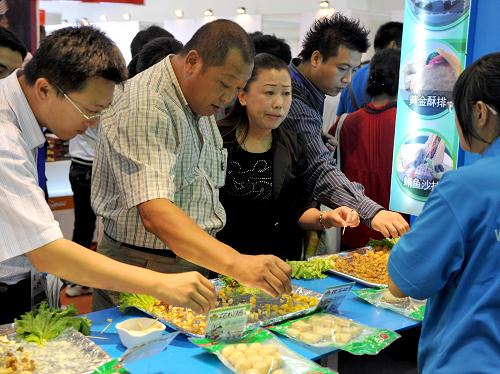 觀眾在東北亞博覽會(huì)上品嘗臺(tái)灣展臺(tái)上的食品(9月4日攝)。新華社記者 蔣林 攝