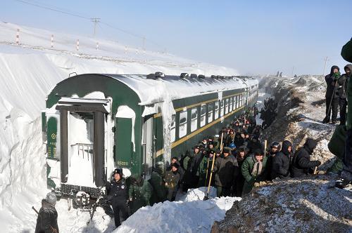 1月4日,消防戰(zhàn)士在內(nèi)蒙古商都受暴雪圍困的旅客列車邊除雪搶險。受暴風(fēng)雪影響,從1月3日開始,呼和浩特鐵路局管內(nèi)多趟旅客列車因雪災(zāi)滯留晚點,部分列車受困于偏遠路段。災(zāi)情發(fā)生后,內(nèi)蒙古自治區(qū)有關(guān)部門會同呼和浩特鐵路局緊急動員近萬名職工、公安消防戰(zhàn)士奔赴搶險第一線,集中搶救疏散受困旅客。鐵路沿線地方政府大力配合,鑿冰除雪保暢通,力爭把災(zāi)害損失減小到最低限度。截至1月4日14時,受困于商都境內(nèi)暴雪區(qū)的1400多名旅客均已就近安置。目前,抗災(zāi)搶險工作正在進行中。新華社發(fā)(田瑜 攝)