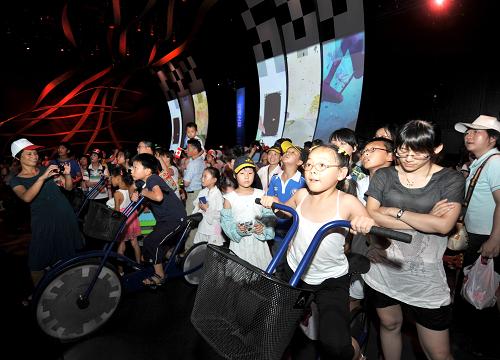 7月31日,游客在世博園加拿大館互動(dòng)體驗(yàn)區(qū)體驗(yàn)飛輪車。中國2010年上海世博會(huì)六個(gè)月的會(huì)期已過半。截至31日,世博園區(qū)累計(jì)接待觀眾接近3500萬人次,三個(gè)月內(nèi)日均接待觀眾約38萬人次。新華社記者 聶建江 攝