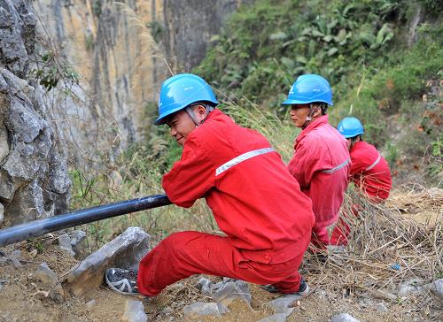 3月26日,在廣西百色市凌云縣伶站瑤族自治鄉(xiāng)巖流瑤寨,工作人員在幫助村民從100多米的山谷中引水。長時間干旱給廣西13個市、85個縣(市)帶來嚴(yán)重影響。面對嚴(yán)重的旱情,旱區(qū)社會各界積極投入到抗旱救災(zāi)中,攜手共渡難關(guān)。新華社記者 周華 攝
