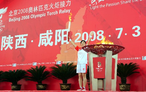 7月3日,最后一棒火炬手史紅艷引燃圣火盆后向觀眾揮手致意。當(dāng)日,北京奧運(yùn)會(huì)圣火在陜西咸陽(yáng)傳遞。 新華社記者 焦衛(wèi)平 攝