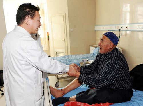 來自新疆布爾津縣沖乎爾鄉(xiāng)81歲的庫爾曼別克老人在向新疆維吾爾自治區(qū)人民醫(yī)院布爾津縣分院院長郭志偉(左)表示感謝(2月13日攝)。新華社記者 沙達(dá)提 攝