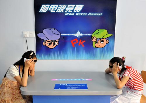 5月31日,兩名學生在思維科學體驗館內進行“腦電波競賽”。通過腦電波感測器,用思考的“力量”將臺子上的小球推向對方。當日,南京市中小學校首家“少兒思維科學研究院”在市三牌樓小學成立,實施相關科學實踐項目的“錢學森班”同時揭牌。“少兒思維科學研究院”下設5個研究所和1個體驗館,體驗館內陳列與思維科學相關的人腦模型、錯覺圖表、腦電波實驗裝置、生物反饋儀、演示沙盤和機器人等展示體驗品,可開展數學、文字等各種趣味游戲,讓學生了解人類大腦及思維活動的知識,懂得科學思維的基本方法。學校建立“少兒思維科學研究院”旨在組織學生開展思維科研實踐,引導他們正確用腦,提高學習效率和培養(yǎng)創(chuàng)新思維。新華社記者 孫參 攝