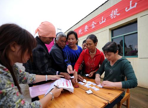 6月4日,在新建縣望城新區(qū)垃圾中轉(zhuǎn)站,幾位居民送完生活垃圾后憑票據(jù)領(lǐng)取購物券。新華社記者 周科 攝