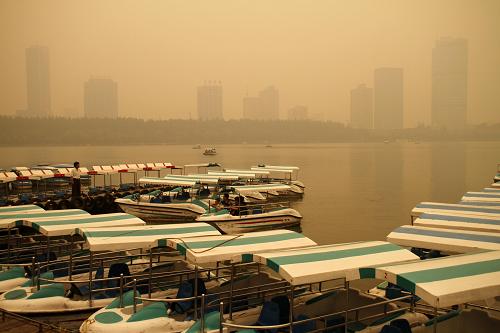 6月10日,游客在陰霾籠罩下的南京玄武湖上乘船游玩。南京地區(qū)當(dāng)日出現(xiàn)能見度小于3000米的霾。自6月9日起,江蘇省部分地區(qū)出現(xiàn)的夏季秸稈焚燒情況,加上靜風(fēng)、高濕、低壓等不利擴(kuò)散的氣象條件,導(dǎo)致部分城市空氣質(zhì)量明顯下降。據(jù)了解,5月下旬以來,江蘇及周邊地區(qū)進(jìn)入秸稈焚燒高峰期。據(jù)衛(wèi)星遙感影像解譯和現(xiàn)場巡查結(jié)果,各地均存在不同程度的秸稈焚燒現(xiàn)象,其中,南京、揚(yáng)州、鎮(zhèn)江以及泰州等地較為嚴(yán)重。針對各地出現(xiàn)的空氣質(zhì)量下降情況,江蘇省環(huán)保廳立即啟動了應(yīng)急防控預(yù)案,江蘇省大氣污染防治辦公室、省環(huán)境監(jiān)察局等部門緊急行動,全面防控。新華社發(fā)(董金林 攝)