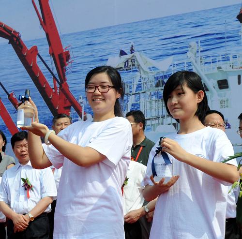 7月16日,兩名中學(xué)生在展示海試團隊贈送的7000米深度海底水樣。新華社記者 李紫恒 攝