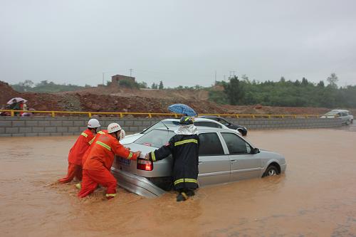 8月5日,消防官兵在湖北省十堰市鄖縣經(jīng)濟(jì)開(kāi)發(fā)區(qū)一條積滿雨水的道路上轉(zhuǎn)移被困車輛。 新華社發(fā)(曹忠宏 攝)