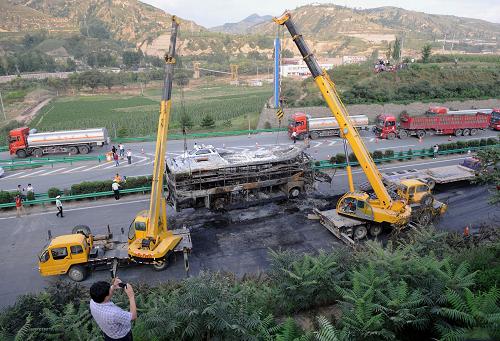 8月26日下午,工作人員用吊車將事故車輛清理出包茂高速公路。新華社發(fā)