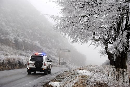 1月8日,威寧交警大隊的警車在梅花山結(jié)冰的公路上巡邏。連日來,貴州省大范圍出現(xiàn)低溫凍雨天氣,貴州102省道梅花山路段時常發(fā)生凝凍,讓原本就行駛困難的道路更加危險。該路段位于六盤水西部,是貴州通往云南宣威、昭通、四川宜賓及貴州威寧縣的交通咽喉,全長16公里,沿線均為盤山道路,海拔最高處達2680米,是貴州省公路海拔最高的路段。威寧交警大隊梅花山執(zhí)勤點的交警們,聯(lián)合威寧交通局,采用徒步巡邏、跟車護送、警車巡路、鋪沙撒鹽等方式,全力保障過往司乘人員的安全,確保道路暢通。新華社發(fā)(楊文斌 攝)