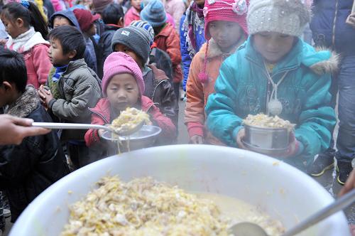 1月8日,在廣西隆林各族自治縣德峨鄉(xiāng)龍洞小學(xué),孩子們?cè)谂抨?duì)領(lǐng)取營養(yǎng)午餐。新華社記者 周華 攝