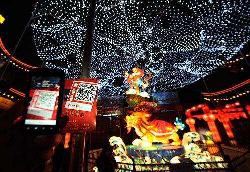 2月6日,市民在南京夫子廟里的大型燈組前用手機(jī)刷二維碼,獲取祝福語。當(dāng)晚,為期20多天的2013年江蘇·秦淮燈會在南京夫子廟——秦淮風(fēng)光帶亮燈開展。本屆燈會以“秦淮燈彩甲天下,百姓歡騰迎新春”為主題,在夫子廟、秦淮河、中華門、老城南門東地段等區(qū)域設(shè)8大展區(qū),共有120余組大中型燈組、50萬盞花燈同時(shí)亮相。燈會注重節(jié)能環(huán)保,多采用節(jié)能燈泡,同時(shí)還首次引用了二維碼技術(shù),觀燈市民用手機(jī)掃描燈組二維碼,便可顯示祝福語、燈謎答案、觀燈指南等信息。新華社記者 孫參 攝