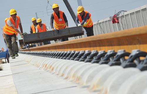 6月12日,中鐵二局新運(yùn)公司的工人在大西鐵路客運(yùn)專線山西運(yùn)城段鋪軌。全長(zhǎng)859公里的大(同)西(安)鐵路客運(yùn)專線目前全面進(jìn)入軌道工程施工階段。大西鐵路客運(yùn)專線設(shè)計(jì)時(shí)速250公里,總投資約970億元,預(yù)計(jì)2014年開通運(yùn)營(yíng)。新華社發(fā)(高新生 攝)