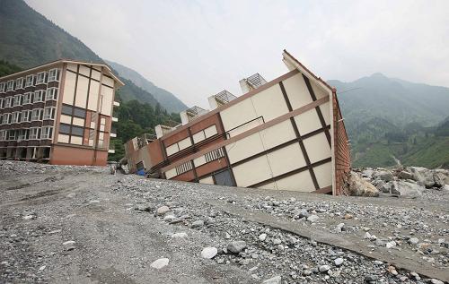 7月15日拍攝的四川省彭州市龍門山鎮(zhèn)一被水沖倒的小區(qū)樓房。連日持續(xù)暴雨導(dǎo)致的洪水將四川省彭州市龍門山鎮(zhèn)白水河河堤沖毀,直接威脅著附近近千名群眾的生命安全。7月13日,應(yīng)成都市政府的請求,成都軍區(qū)空軍工程部隊(duì)的100余名官兵趕赴龍門山鎮(zhèn)展開救援。截至15日21時(shí),官兵們已將河道疏通,后續(xù)還將拓寬河床徹底排除險(xiǎn)情,使當(dāng)?shù)厝罕姲踩冗^雨季。新華社發(fā)(易開紅 攝)