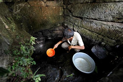 8月7日,在貴州省貴陽(yáng)市修文縣六桶鎮(zhèn)復(fù)興村,村民在幾乎干涸的水井中一點(diǎn)點(diǎn)舀水。新華社發(fā)(吳東俊 攝)