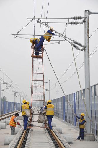 4月25日,中鐵電氣化局集團施工人員在京滬高鐵北京南至廊坊區(qū)間北京區(qū)段對電氣化接觸網(wǎng)進行最后的精細調(diào)試。新華社發(fā)(李朝臻 攝)