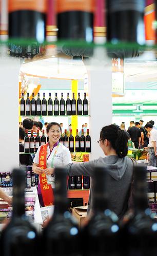 6月15日,在伊春森林食品展區(qū),工作人員在向市民在介紹一款飲品的情況。新華社記者 王建威 攝