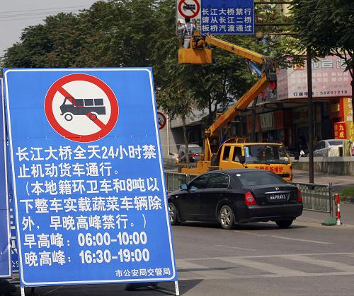 9月6日,車輛從南京長(zhǎng)江大橋南引橋入口處設(shè)置的禁止機(jī)動(dòng)貨車通行標(biāo)識(shí)牌旁經(jīng)過(guò)。自當(dāng)日起,除本地籍環(huán)衛(wèi)車和8噸以下整車實(shí)載蔬菜車以外,南京長(zhǎng)江大橋全天24小時(shí)禁止機(jī)動(dòng)貨車通行。據(jù)悉,此舉是為了保障建成40多年的南京長(zhǎng)江大橋的安全。新華社發(fā)(王新 攝)