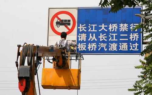 9月6日,工作人員在南京長(zhǎng)江大橋南引橋入口處更新禁止機(jī)動(dòng)貨車通行標(biāo)識(shí)牌。新華社發(fā)(王新 攝)