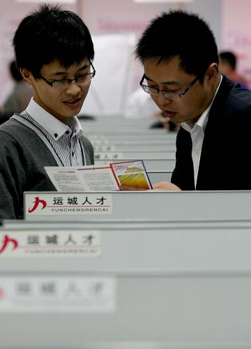 9月6日,在晉陜豫黃河金三角地區(qū)首屆人力資源招聘大會上,一家招聘單位的工作人員(右)向求職者介紹單位情況。新華社發(fā)(衛(wèi)行智 攝)