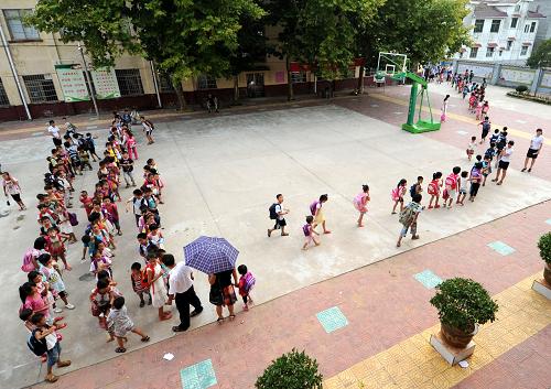 9月8日,南豐縣萊溪鄉(xiāng)中心小學(xué)的學(xué)生們放學(xué)回家。 近年來,隨著農(nóng)村經(jīng)濟的發(fā)展,農(nóng)民對子女的期望值增加,學(xué)生擇校特別是進城借讀情況愈演愈烈,導(dǎo)致農(nóng)村中小學(xué)生源大量流失,出現(xiàn)一大批“超小”的農(nóng)村中小學(xué)和幾個“超大”規(guī)模的縣城學(xué)校。為優(yōu)化教育資源配置,推進城鄉(xiāng)教育均衡發(fā)展,江西南豐縣從2009年開始,實施教育向上集中工程,將全縣初中學(xué)校向縣城及部分中心鎮(zhèn)集中,農(nóng)村小學(xué)向鄉(xiāng)鎮(zhèn)所在地及中心村集中,實施城鄉(xiāng)聯(lián)動,分步推進。目前,全縣共建有3所“九年一貫制”學(xué)校,22所農(nóng)村中小學(xué)實行了寄宿制。新華社記者周科攝