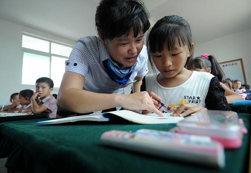 9月8日,南豐縣萊溪鄉(xiāng)中心小學(xué)六年級數(shù)學(xué)老師在為一名學(xué)生講解課本知識。新華社記者周科攝