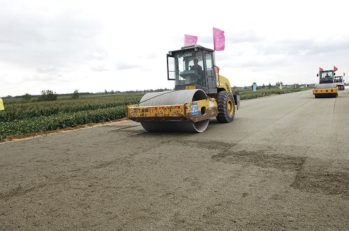 9月20日,江蘇臨海公路大豐段工點(diǎn)壓路機(jī)在已經(jīng)鋪上沙石的路面上進(jìn)行碾壓施工。新華社發(fā)(沈鵬 攝)