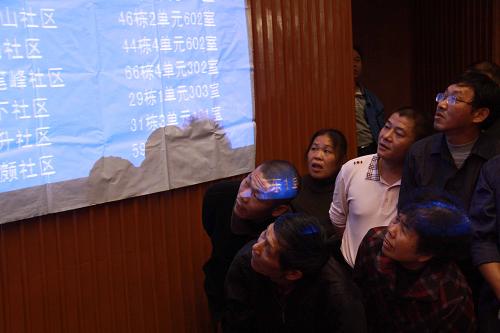 9月21日,在宜春中心城區(qū)2011年保障性住房配售配租公開搖號儀式上,市民在觀看保障房搖號結果。新華社發(fā)(鄒海斌 攝)