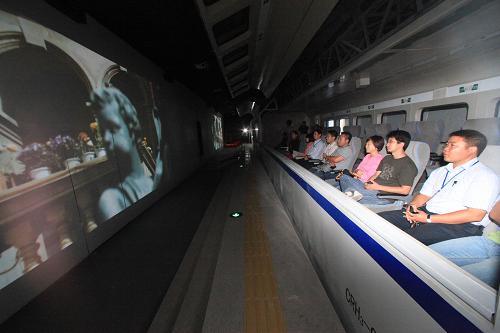 9月21日,觀眾在世博會天津館“動車影院”觀看視頻短片。新華社發(fā)