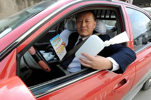 2月27日,一名蘇州市區(qū)的出租車(chē)司機(jī)展示剛領(lǐng)到的免費(fèi)便攜式應(yīng)急坐便器。新華社發(fā)(杭興微 攝)