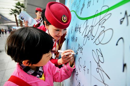 4月22日,一名小朋友在高鐵服務(wù)員的幫助下在宣傳板上簽名。當日,天津火車站開展“關(guān)愛地球、綠色出行”主題服務(wù)活動,迎接第43個“世界地球日”。京津城際高鐵客運服務(wù)人向旅客宣傳“世界地球日”的理念,倡導廣大旅客選擇公共交通工具,節(jié)約資源、綠色出行,以自身行動關(guān)愛地球。新華社發(fā)(楊寶森 攝)