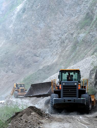 9月9日,挖掘機在疏通前往重災區(qū)洛澤河鎮(zhèn)的唯一道路。新華社記者 秦晴 攝