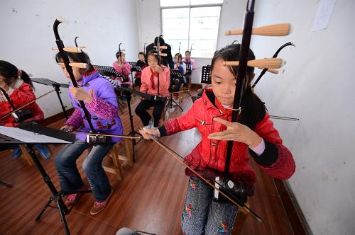 11月22日,江西樟樹吳城鄉(xiāng)吳城中心小學(xué)少年宮里,老師在教學(xué)生們拉二胡。新華社記者周密攝