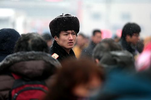 2月3日,北京火車(chē)站的工作人員在雪中疏導(dǎo)乘客。新華社記者 金立旺 攝