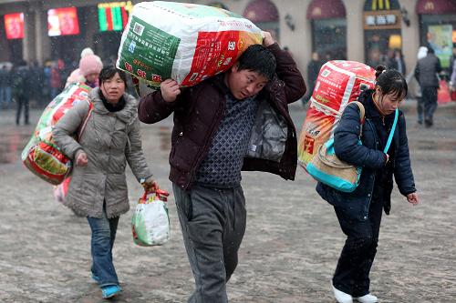 2月3日,北京火車站,人們?cè)陲L(fēng)雪中踏上歸程。新華社記者 金立旺 攝