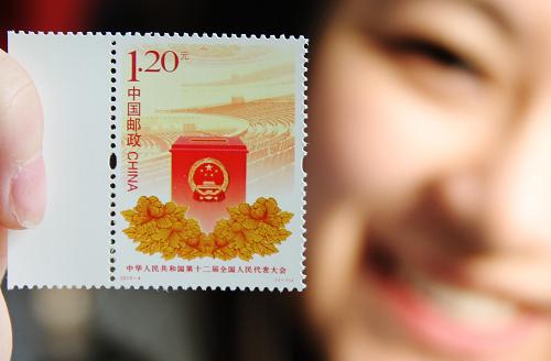 3月5日,一名集郵愛好者在江蘇蘇州郵政局展示剛購買的《中華人民共和國第十二屆全國人民代表大會》紀念郵票。當日,中國郵政發(fā)行《中華人民共和國第十二屆全國人民代表大會》紀念郵票1套1枚。郵票以投票箱為前景和主體形象,以人民大會堂內(nèi)景為背景,傳統(tǒng)的牡丹花紋樣裝飾于投票箱下方,面值為1.20元。新華社發(fā)(朱桂根 攝)