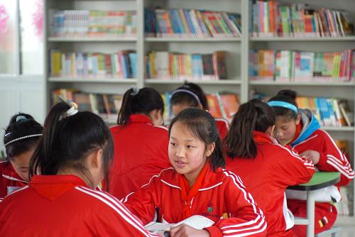 3月14日,在張家港市白云學校的公益書屋,老家在湖北竹溪的六年級學生賀欣雨和同學們一起在放學后讀課外書。新華社發(fā)(李響 攝)