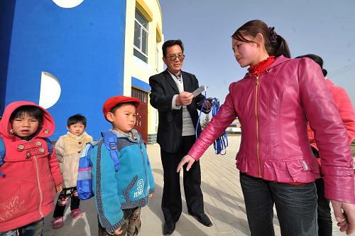 3月14日,在寧夏回族自治區(qū)隆德縣清泉生態(tài)移民新村幼兒園內(nèi),老師在對(duì)照親子接送卡讓家長接自己的孩子。新華社記者 彭昭之?dāng)z