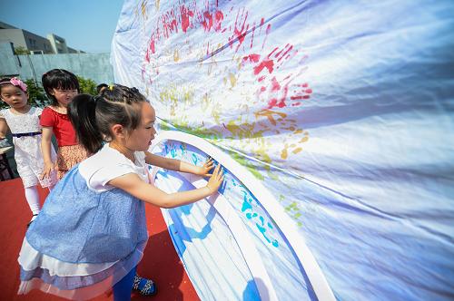 5月21日,孩子們用沾滿(mǎn)顏料的雙手在畫(huà)布上繪制彩虹。當(dāng)日,杭州文天社區(qū)在祥符藝術(shù)幼兒園舉行了一場(chǎng)“童心創(chuàng)想”迎六一活動(dòng)。以“環(huán)保、創(chuàng)意、夢(mèng)想”為主題的“童心創(chuàng)想”活動(dòng),包括了環(huán)保時(shí)裝秀、把夢(mèng)想寫(xiě)在紙飛機(jī)上放飛、印出彩虹手印以及京劇臉譜表演等多項(xiàng)內(nèi)容。 新華社記者 徐昱 攝