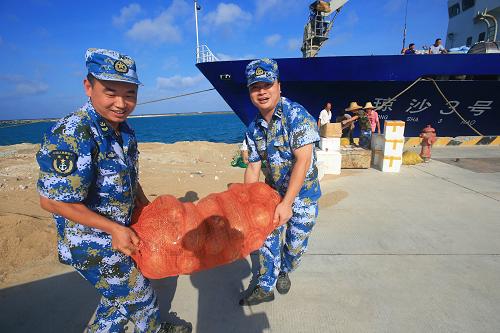 5月21日,駐守在永興島上的海軍官兵在碼頭搬運(yùn)“瓊沙3號(hào)”運(yùn)來的生活物資。新華社記者 查春明 攝