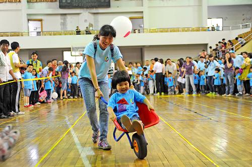 5月28日,幼兒園小朋友和家長(zhǎng)一起參加小推車比賽。新華社記者 沈鵬 攝