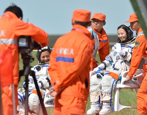6月26日,女航天員王亞平(右)自主出艙后揮手致意。新華社記者任軍川攝