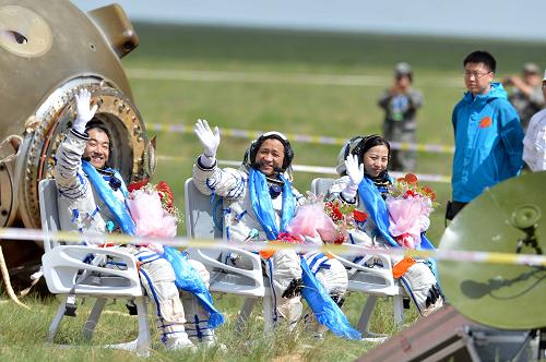 6月26日,這是圓滿完成任務的三位航天員張曉光、聶海勝、王亞平(從左至右)自主出艙后向人們致意。新華社記者 任軍川攝
