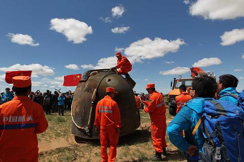 6月26日,神舟十號(hào)載人飛船返回艙成功著陸,三名航天員出艙后,工作人員現(xiàn)場(chǎng)對(duì)返回艙進(jìn)行處置。新華社記者王建民攝