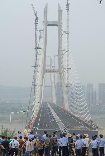 6月26日,不少市民來到江津鼎山長江大橋通車現(xiàn)場慶賀通車。當日,“橋都”重慶又新增一座長江大橋,總投資28億元,同時也是重慶第一座公軌兩用斜拉橋—江津鼎山長江大橋建成通車。大橋的通車不僅構(gòu)建了四通八達的立體交通網(wǎng)絡(luò),而且也拉動了江津區(qū)及其周邊區(qū)縣與重慶主城區(qū)的經(jīng)濟聯(lián)系。 新華社記者陳誠攝