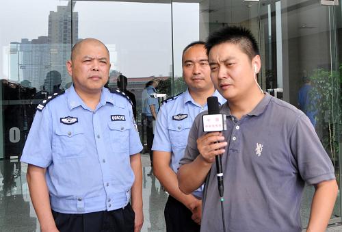 8月14日,民警王曉渝(后左一)、周縉(后左二)在接受媒體采訪。新華社記者 劉潺 攝