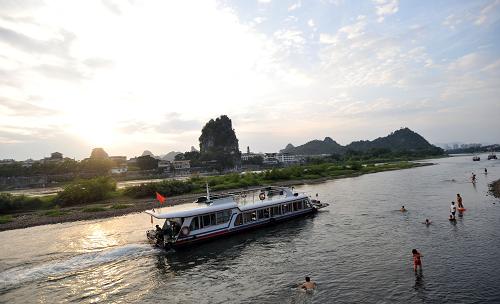 桂林推進(jìn)旅游轉(zhuǎn)型升級(jí) 8月19日,幾艘游船載著游客從桂林漓江伏波山前經(jīng)過(guò)。 目前,世界著名風(fēng)景旅游城市和歷史文化名城桂林市,正乘著“建設(shè)桂林國(guó)家旅游綜合改革試驗(yàn)區(qū)”的東風(fēng)推進(jìn)旅游轉(zhuǎn)型升級(jí),取得了初步成效。今年上半年,全市旅游共接待境內(nèi)外旅游者1482.44萬(wàn)人次,同比增長(zhǎng)17.66%,實(shí)現(xiàn)旅游總收入111.61億元。 據(jù)悉,桂林市旅游轉(zhuǎn)型升級(jí)將實(shí)現(xiàn)“五轉(zhuǎn)變”,即旅游產(chǎn)品由單一觀光型向多元復(fù)合型轉(zhuǎn)變,經(jīng)營(yíng)方式由粗放型向集約型轉(zhuǎn)變,發(fā)展模式由規(guī)模數(shù)量型向規(guī)模質(zhì)量效益并重型轉(zhuǎn)變,旅游供給由滿足游客基本消費(fèi)需求向提供高質(zhì)量服務(wù)轉(zhuǎn)變,旅游功能由單純注重經(jīng)濟(jì)功能向積極發(fā)揮綜合功能轉(zhuǎn)變。 新華社記者 陸波岸 攝