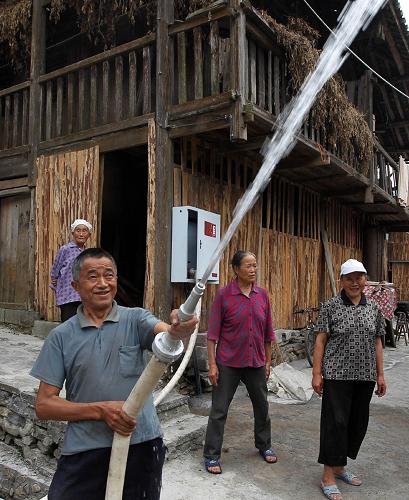 何家院子的一名住戶在試用消防水槍(8月22日攝)。日前,一個嶄新的消火栓正式入駐重慶市黔江區(qū)小南海鎮(zhèn)新建村4組的何家院子——一座有著200年歷史的土家族院落。據(jù)了解,這個消火栓的建成并投入啟用,正式結(jié)束了重慶市廣大農(nóng)村沒有村級消火栓的歷史。據(jù)悉,何家院子共安裝了3個消火栓,配備有消防專用水帶、水槍,可供周圍1公里范圍內(nèi)農(nóng)村居民的滅火使用。除滅火救援外,消火栓還可以在必要時用作人畜用水和灌溉農(nóng)田。黔江區(qū)位于重慶市的東南邊緣,地處武陵山腹地,是重慶市主要的少數(shù)民族聚居地之一。何家院子是黔江區(qū)3266個大院中具有濃郁土家族特色的鄉(xiāng)村民居,至今已有200年歷史,共有16戶68人。