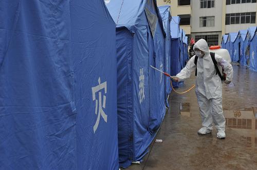 9月12日,防疫工作人員在彝良縣角奎鎮(zhèn)新場小學安置點噴灑消毒劑。新華社記者 歐東衢 攝