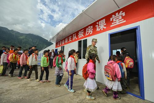 9月13日,大寨小學(xué)的學(xué)生排隊進(jìn)入板房課堂。新華社記者 李鑫 攝